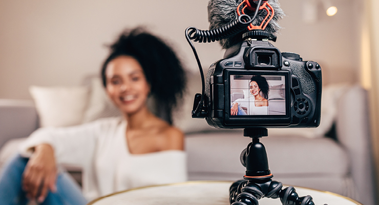 Female recording a video on her camera for social media marketing to grow her business.