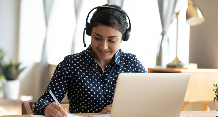 A student wearing a headset taking an online test.